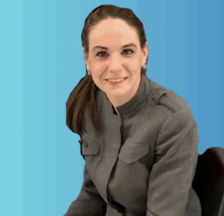 Woman with brown hair pulled back in a pony tail is seated while smiling